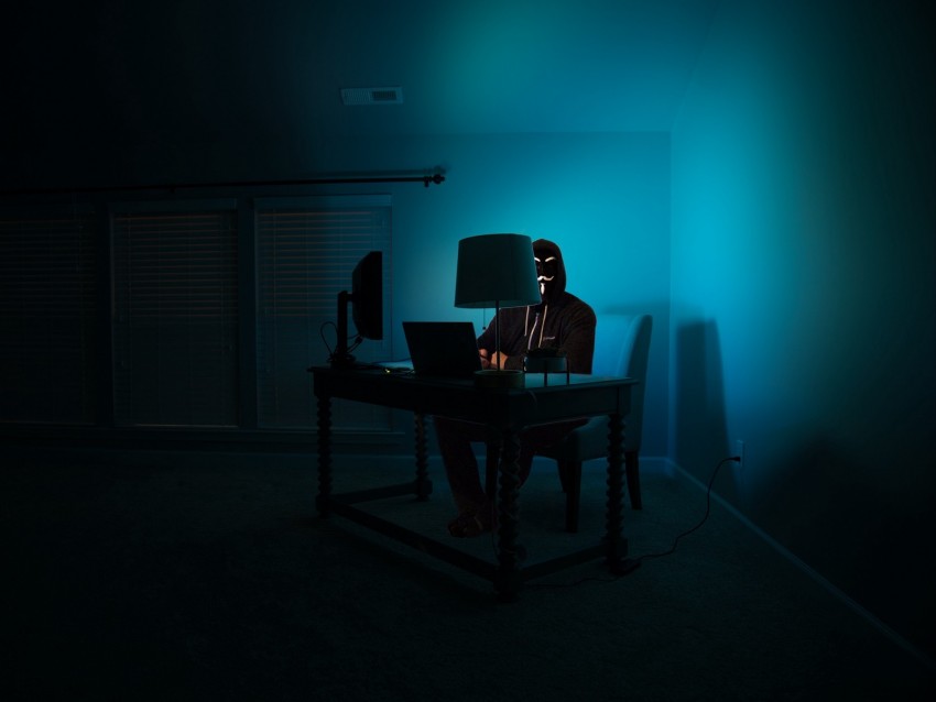 hacker, dark office, computer desk, mysterious figure, low light