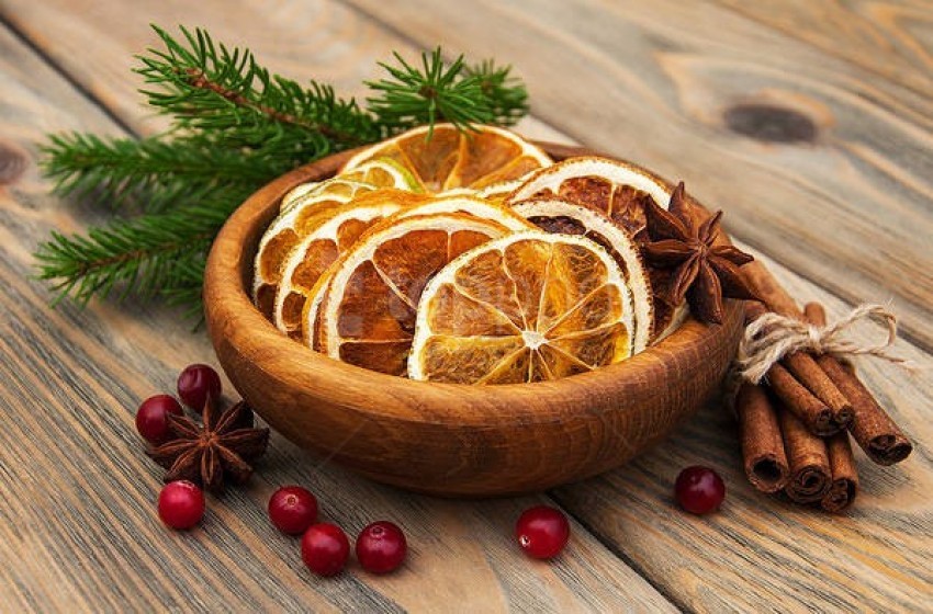 dried fruit, orange slices, cinnamon sticks, star anise, pine branches, wooden bowl, holiday decorations