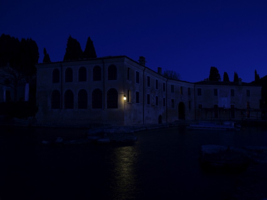 mystical building, nighttime scenery, illuminated architecture, water reflection, historic structure