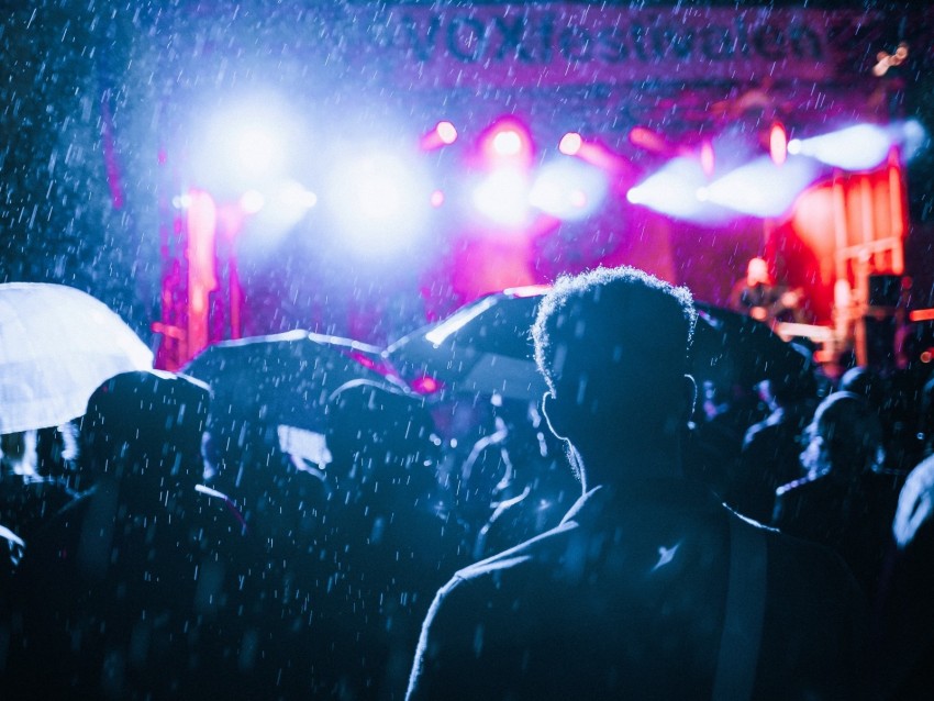 music festival, concert crowd, rainy weather, night lights, vibrant atmosphere