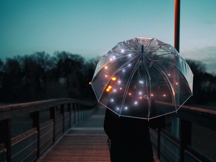 lit umbrella, night photography, decorative lights, outdoor scene, rainy day